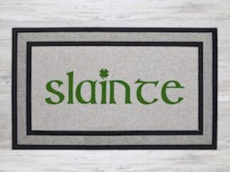 Mockup of a saint patrick's day themed doormat featuring the phrase, "slainte" in a bold kelly green font with a shamrock dotting the "I"