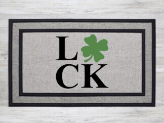 Mockup of a St. Patrick's Day themed welcome mat featuring the phrase, "LUCK" with a green shamrock in place of the letter 'U'.