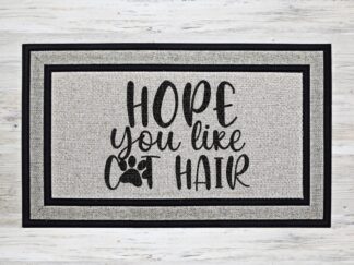 Mockup of a doormat inspired by pet lovers featuring the phrase, "Hope you like Cat Hair" in a bold black font