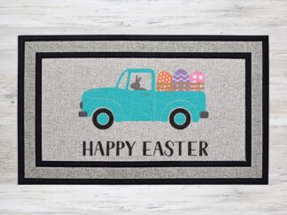 Mockup of an Easter themed doormat that features the phrase "Happy Easter" with an adorable grey bunny driving a blue farm truck with Easter eggs in the back