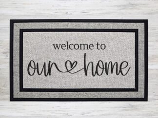 Mockup of a doormat that says, "welcome to our home" in a bold black font with a cute heart between the words 'our' and 'home'.