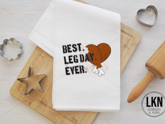 White dish towel with black text 'Best leg day ever' represented by turkey legs.