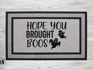 Mockup of a Halloween themed doormat that says "hope you brought the boos" with two flying ghosts.