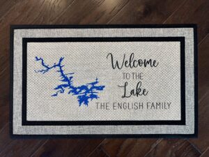 Photo of a doormat for a client at Lake Hamilton in Arkansas, for the English family, that says "Welcome to the Lake, The English Family" with a cartography map of Lake Hamilton.