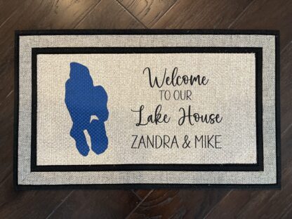 Photo of a doormat for a client at Lower Pettibone Lake in Michigan, for Zandra and Mike, that says "Welcome to our Lake House, Zandra & Mike" with a cartography map of Lower Pettibone Lake.