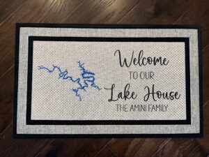 Photo of a doormat for a client at Lake of the Ozarks in Missouri, for the Amini family, that says "Welcome to our Lake House, The Amini Family" with a cartography map of Lake of the Ozarks.