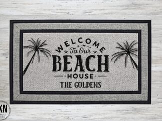 Mockup of a beach themed doormat that says "Welcome to Our Beach House" in a bold black font with palm trees on both sides and is personalized with the family last name underneath.