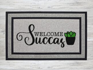 Mockup of a welcome doormat that says, "Welcome Succas" in a bold black font with a small green succulent