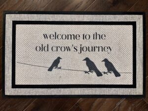 Photo of a custom doormat for a client that wanted the saying, 'Welcome to the Old Crow's Journey' above a line with 3 crows perched on it