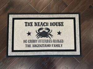 Photo of a custom beach house doormat for the Argenziano family, featuring a crab with the saying, 'The Beach House - No Crabby Attitudes Allowed - The Argenziano Family'