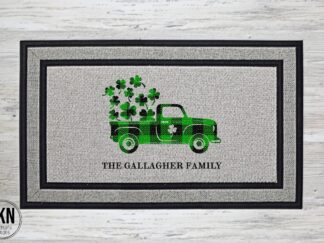 Mockup of a St. Patrick's Day themed welcome mat featuring a green buffalo plaid farm truck with shamrocks in the back and your family name underneath.